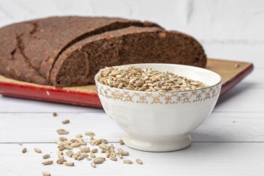 Tohumlu çavdar ekmeği bir ışık masasında yatıyor. Tohumlar ve kırıntılar