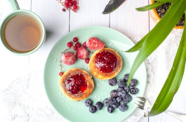 Ahududu reçelli süzme peynirli krep, yaban mersini ve çilek. Yukarıdan bak. Kahvaltı.