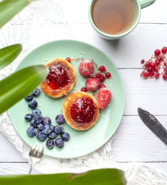 Ahududu reçelli cheeseccakes, bir fincan çayla servis edilen böğürtlen, cheesecakes