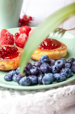 Ahududu reçelli cheeseccakes, bir fincan çayla servis edilen böğürtlen, cheesecakes