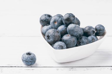 Beyaz arka planda bir tabak kupa yaban mersini. Taze olgun böğürtlenler. Yemek konseptine bayılırım. Üst görünüm, düz görünüm, kopyalama alanı.