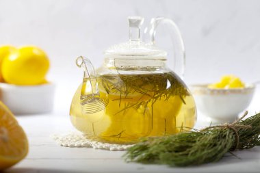 Sıcak at kuyruklu çaydanlık bitkisel çay ve taze yeşil dallar.