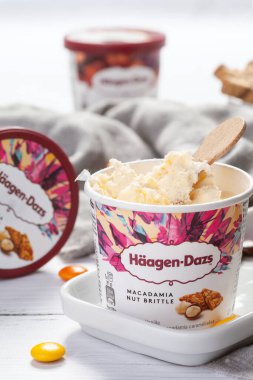 KYIV, UKRAINE - Şubat 06, 2022: HAAGEN-DAZS vanilyalı dondurma bir kova vanilyalı dondurma, ahşap çubuklu karamel aromalı fındık. Yakın plan.