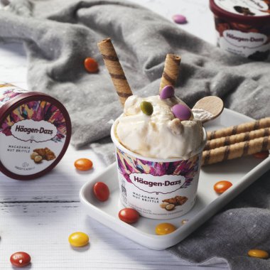 KYIV, UKRAINE - Şubat 08, 2022: renkli şekerli dondurma ve kağıt bardakta gofret ve ahşap sopa. Dondurma Haagen-Dazs