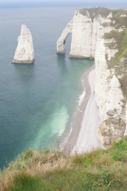 Güneşli bir yaz gününde, Falaise d 'Aval' ın doğal kemeriyle yükselen tebeşir uçurumunun manzarası, Fransa 'nın kuzeybatısında Normandiya.