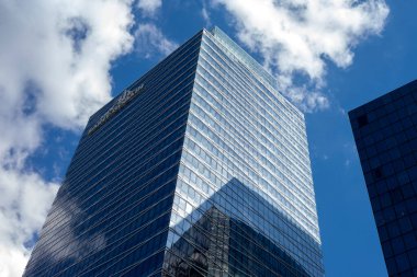 Paris, Fransa - 12 Haziran 2022: Güneşli bir günde mavi gökyüzünde güneş ışınları olan bir gökdelenin cam cepheleri. Paris 'in La Defense iş bölgesinde modern bir bina. Ekonomi, finans, iş konsepti. Alt görünüm