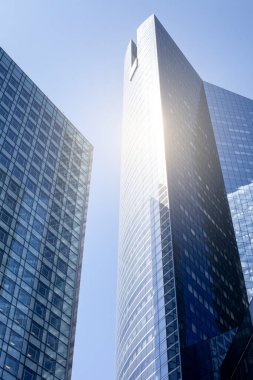 PARIS, FRANCE - 16 Haziran 2022: Mavi gökyüzüne karşı modern gökdelenlerin alt manzarası. Şehir merkezindeki iş binalarına bakıyorum..