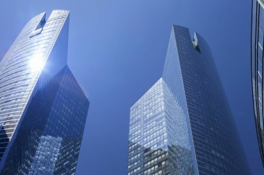 PARIS, FRANCE - 16 Haziran 2022: Mavi gökyüzüne karşı modern gökdelenlerin alt manzarası. Şehir merkezindeki iş binalarına bakıyorum..