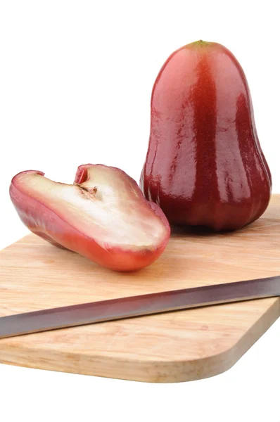 One and a half of red rose apple on chopping board — Stock Photo, Image