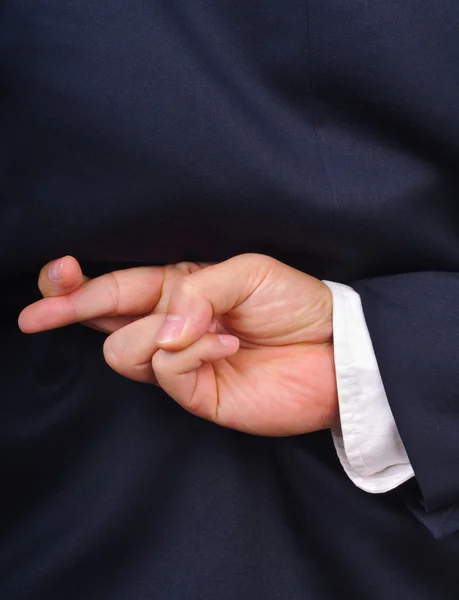 Businessman with fingers crossed behind his back — Stock Photo, Image