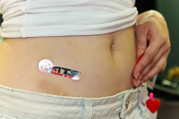 Female presenter with a sticker of ATS Brake system — Stock Photo, Image