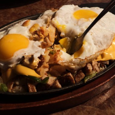 Sosis ve yumurta kahvaltı tavası, kızarmış ekmek ve portakal suyu.