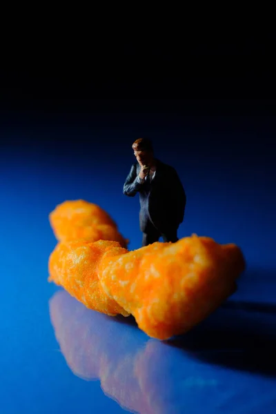 Miniaturowi Biznesmeni Rozważający Ser Puff Niezdrowe Fast Food Snack Makro — Zdjęcie stockowe