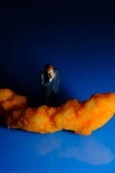 Miniature Businessmen Contemplating Cheese Puff Unhealthy Junk Food Snack Macro — Stock Photo, Image