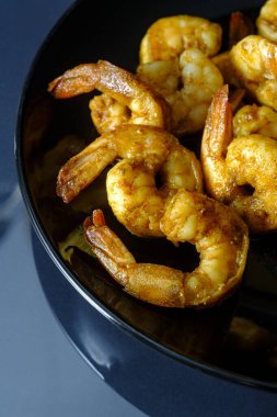 Baharatlı kuyruklu Cajun karides yemeği ya da karamsar ışıklandırmalı aperatif.