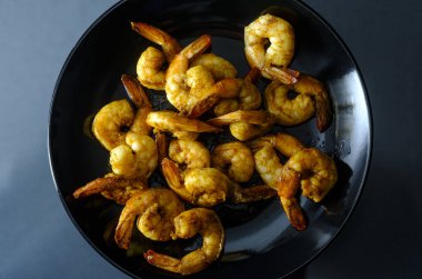 Baharatlı kuyruklu Cajun karides yemeği ya da karamsar ışıklandırmalı aperatif.