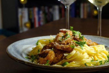 İtalyan fettuccine alfredo ile Cajun karidesi Pinot grigio beyaz şarap ile servis edilir