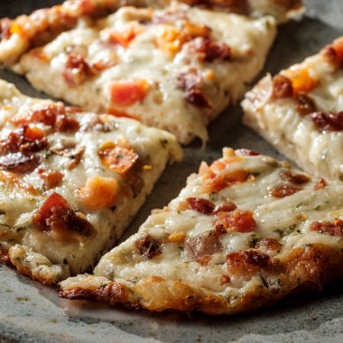 Biberli ve sosisli peynirli birkaç tane pizza.