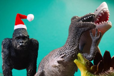 Uninvited for Christmas hysterical laughing bullies mock sad gorilla wearing santa hat as metaphor