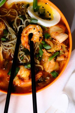 Korean kimchi and shrimp ramen garnished with soft boiled egg and sliced green onion