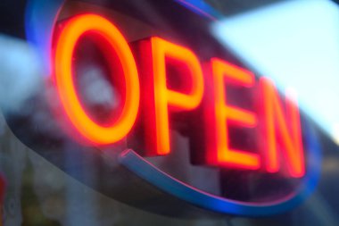 Shallow focus on red neon open sign in shop window