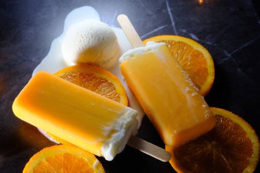 Oranges and cream vanilla ice pops melting on kitchen counter