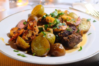 Gourmet surf and turf cajun shrimp and steak dinner entree with new potatoes at a fancy expensive wedding