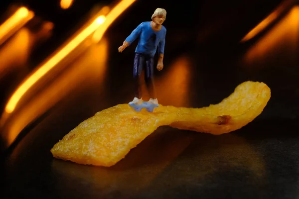 Skateboarding Miniature Man Rides Junk Food Corn Chip — стоковое фото