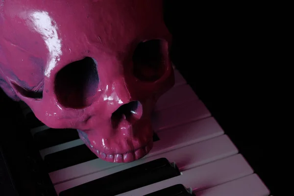 怖い音楽パフォーマンスのための電動ピアノキーボード上のピンクの人間の頭蓋骨 — ストック写真