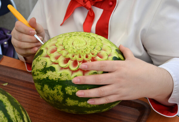 Woman's hands carved watermelon