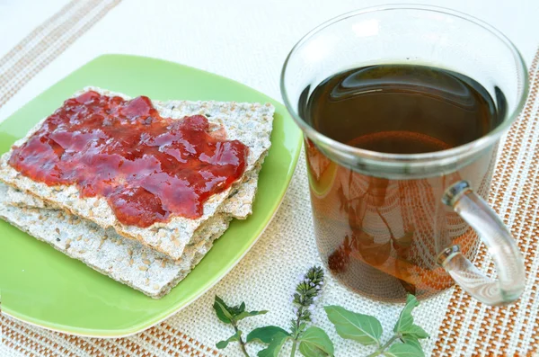 Cracker mit Erdbeermarmelade und Minztee — Stockfoto