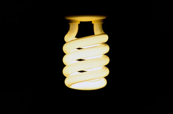 Energy saving lamp on the black background — Stock Photo, Image