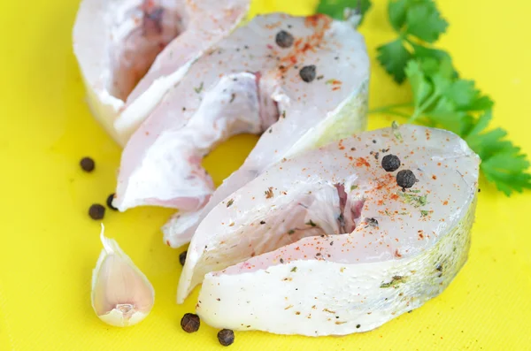 Filete de pescado crudo con ajo y especias Fotos de stock