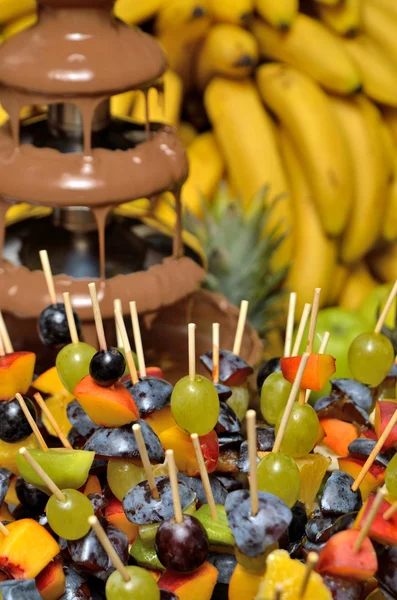 Chocolate fountain with fruit skewers — Stock Photo, Image