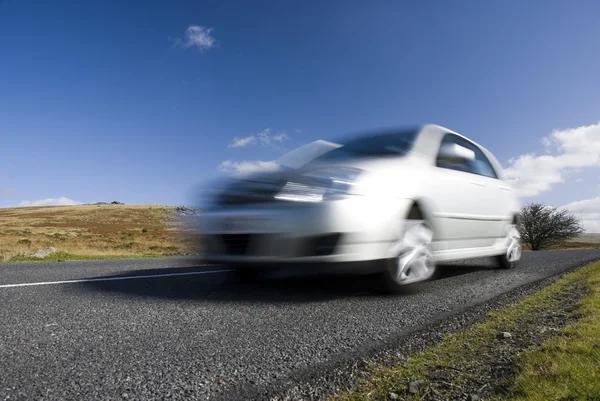 Wazig zilveren auto op bergweg — Stockfoto