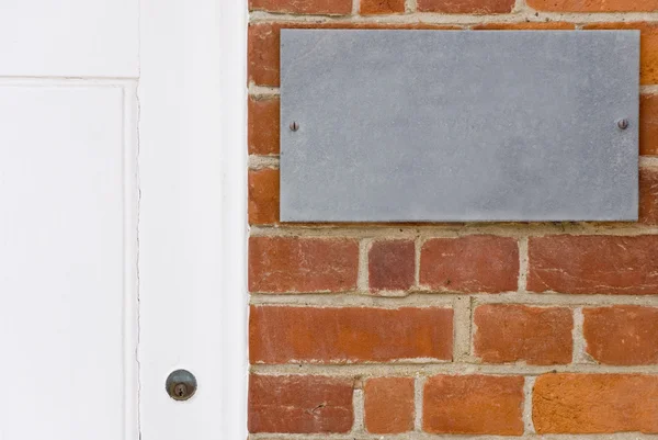 Bakstenen muur en witte deur — Stockfoto