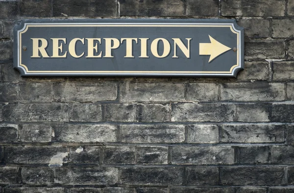 Receptions arrow sign on brick wall — Stock Photo, Image