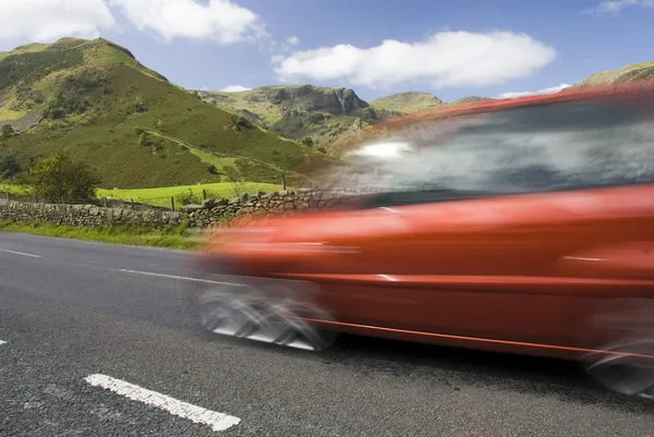 Versnellen van rode auto, lake district, Verenigd Koninkrijk — Stockfoto