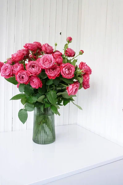 roses in a vase on a white table