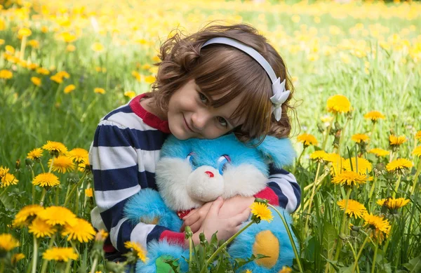 Klein meisje onder gele bloemen — Stockfoto