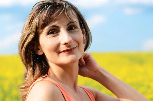 volwassen vrouw portret op de gele fiel