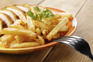 Fransız kızartması ve ahşap masa tabakta tavuk