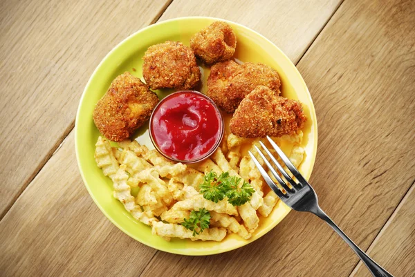 Papas fritas y pollo en el plato de la mesa de madera —  Fotos de Stock