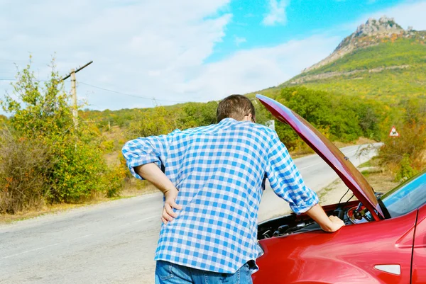 Hombre adulto está de pie cerca de su coche roto —  Fotos de Stock