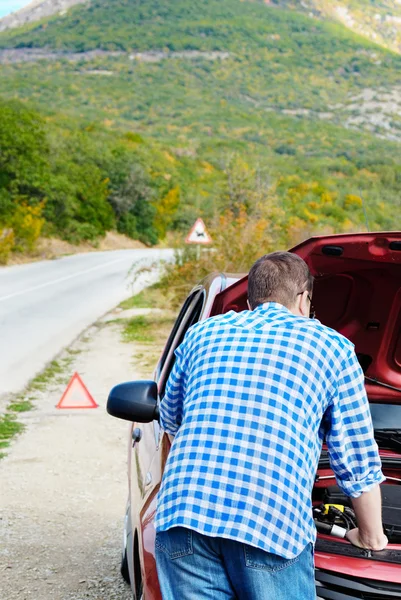 Homem adulto está de pé perto de seu carro quebrado — Fotografia de Stock