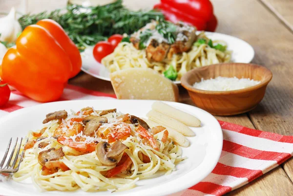 Pasta with shrimps and mashrooms on the wooden table — Stock Photo, Image