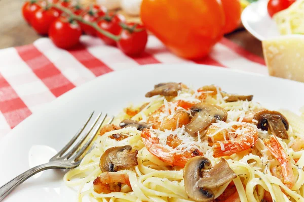 Pâtes aux crevettes et aux champignons sur la table en bois — Photo