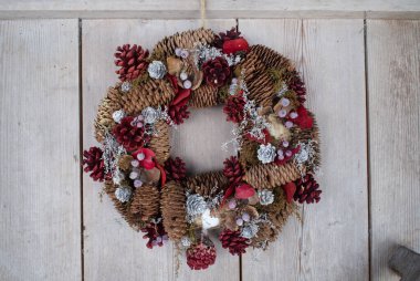 Kapısında köknar konisi olan bir çelenk