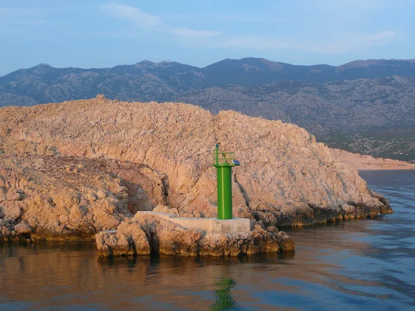 Felsige Küste und grüner Leuchtturm — Stockfoto