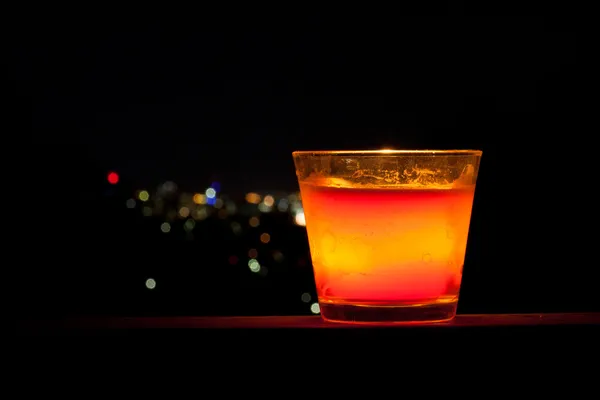 Candle with distant city lights